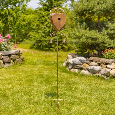 Sikha heart birdhouse stake standing in a green garden showing the decorative leaf and bird sculptures.