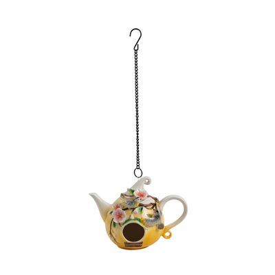 Front view of the porcelain teapot birdhouse showing the round entry hole and hand-painted floral details.