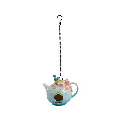 Blue and white gradient porcelain teapot birdhouse with pink floral details and a blue and yellow songbird on top.