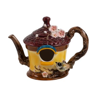 Front view of the porcelain teapot birdhouse highlighting the circular entry hole and hand-painted flowers.