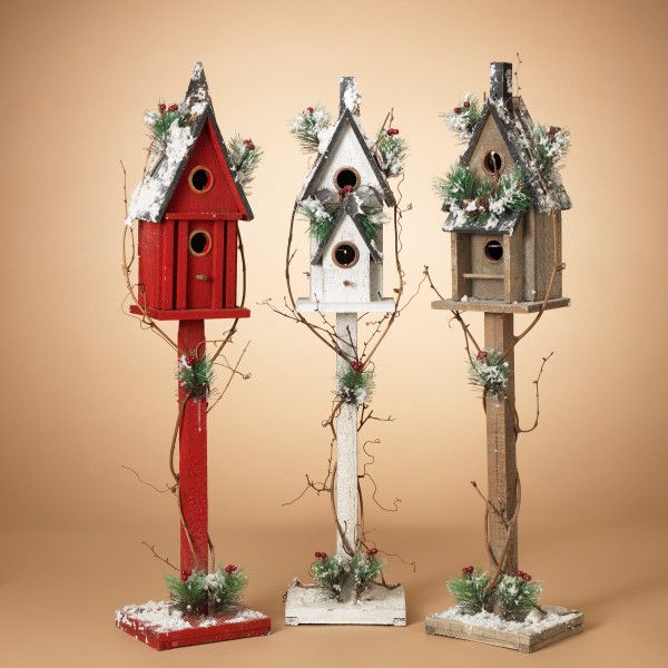 Three assorted 36-inch tall wooden birdhouses in red, white, and natural finishes with winter accents.