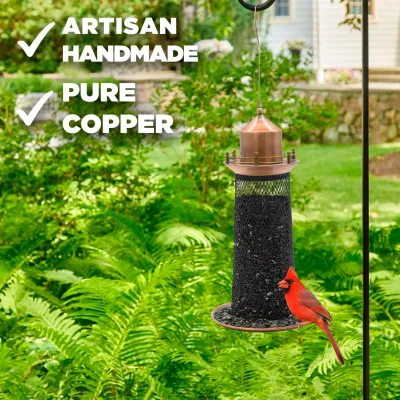 Close-up of the lighthouse feeder emphasizing the pure copper construction and brass railing accents.