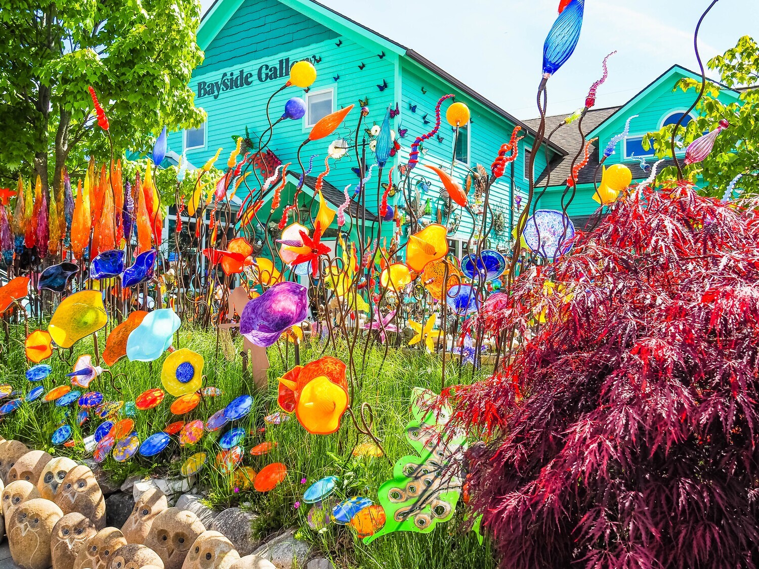 A vibrant digital painting of a colorful glass garden in full bloom, mounted on a small square wooden art block.
