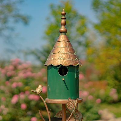 Front view of the Prague Birdhouse Stake featuring a dark green porcelain house with a tiered conical roof and ornate copper-