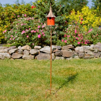 Full view of the 69.25-inch tall birdhouse stake situated in a garden, showcasing the slender iron pole and decorative leaf a