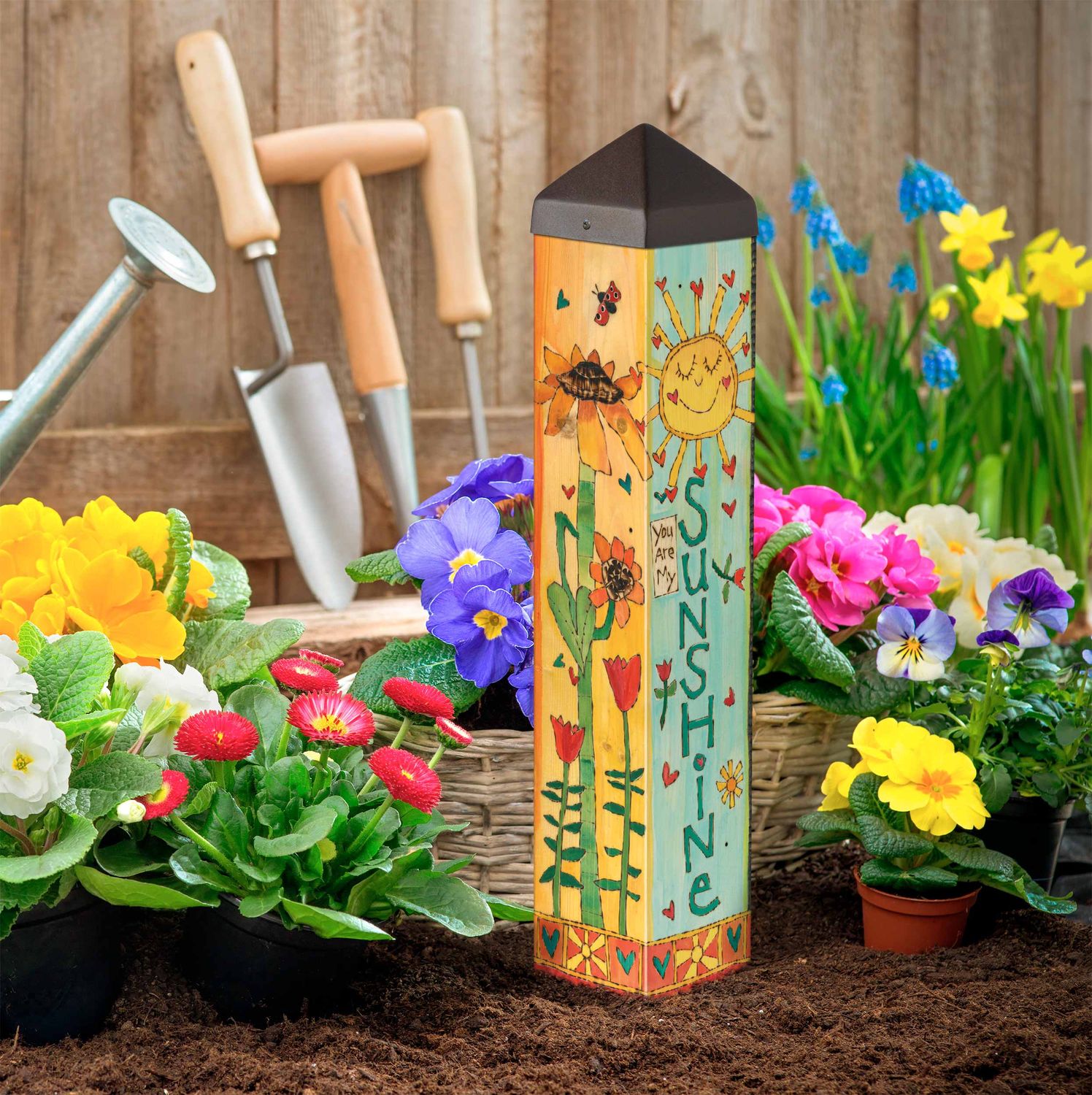 Flat view of the sunny art pole design featuring a smiling sun, house, and bright flowers.