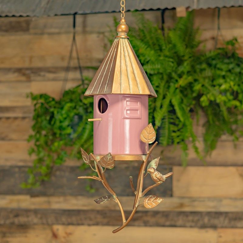 Pink porcelain hanging birdhouse with antique copper metal roof, decorative branches, leaves and small bird accent.