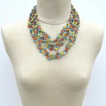A multi-strand statement necklace made of layered natural wood beads in earthy tones, displayed on a beige jewelry bust form.