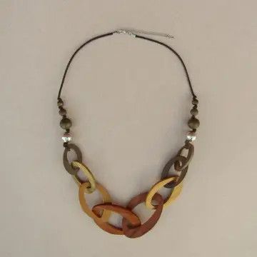 A handcrafted necklace featuring layered wooden charms and beads in warm amber, brown, and turquoise tones strung on a cord