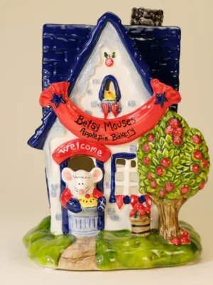A colorful hand-painted ceramic candle house shaped like a cottage labeled "Betsy Mouse’s Applepie Bakery"