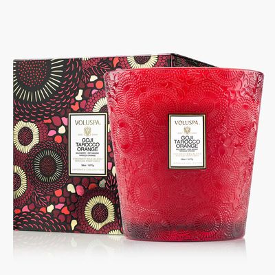 Large three-wick candle in a vibrant red embossed glass jar