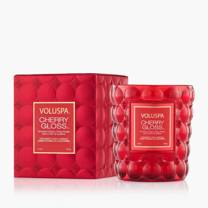 Cherry Gloss Classic Candle in its signature red embossed glass jar alongside its decorative red and gold floral gift box.