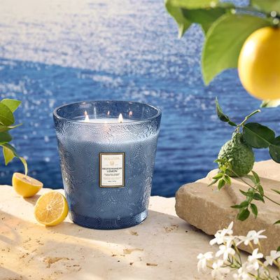 Side view of the Mediterranean Lemon hearth candle showing the textured blue glass and white product label.