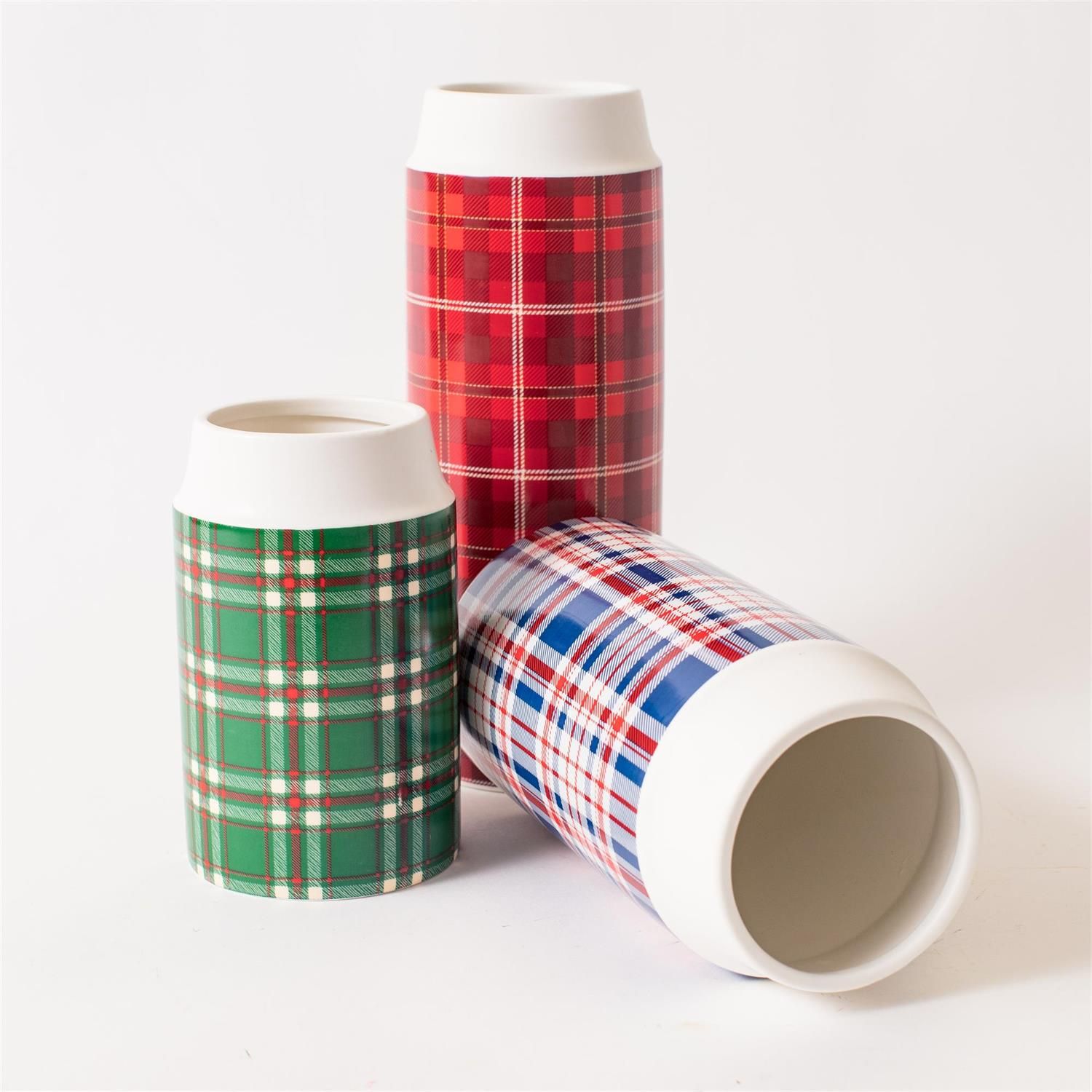Red, blue, and green plaid ceramic vases with white rims displayed together on a white background.
