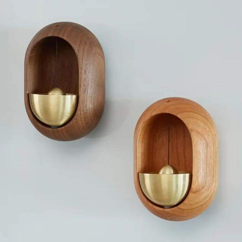 Wall-mounted wooden wind chime with brass bell shown in Natural and Walnut finishes.