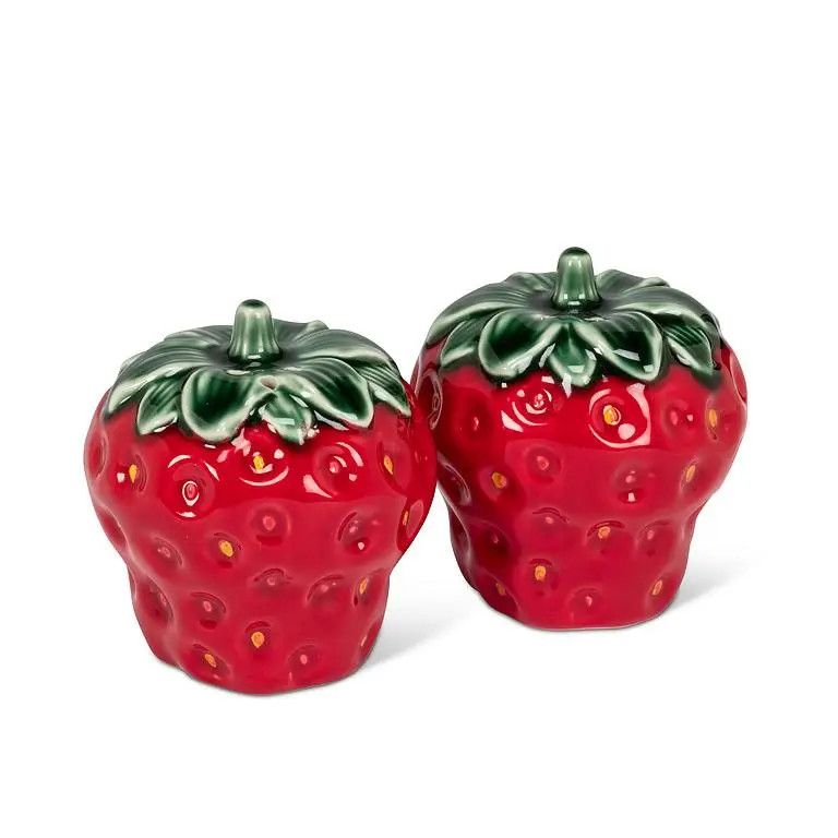 A pair of stoneware salt and pepper shakers shaped like red strawberries with green leafy tops.