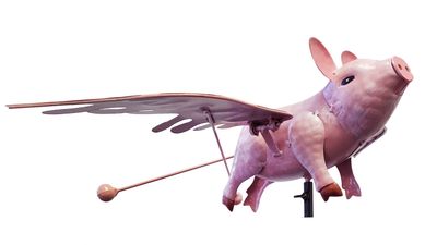 Pink rustic metal flying pig kinetic garden stake with flapping wings and weighted balancing mechanism.