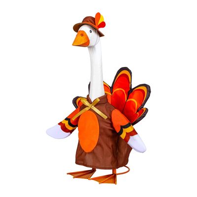 Giddy the Porch Goose modeling a brown turkey costume with an orange belly, gold bow, colorful tail, and feather-accented hat
