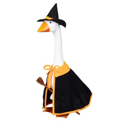 Giddy the Porch Goose modeling a black witch cape with orange trim, a pointed hat, and a miniature broom.