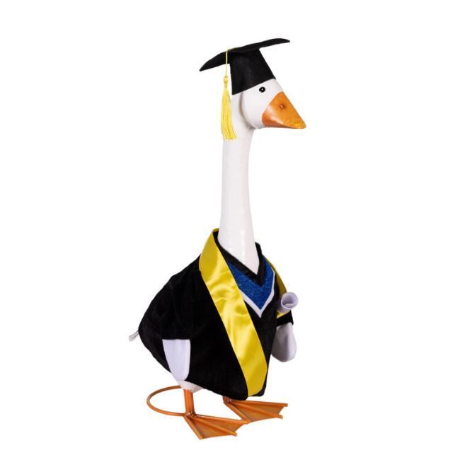 Giddy the Porch Goose wearing a black graduation gown, yellow stole, and mortarboard cap with a yellow tassel, with a rolled 