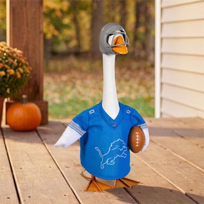 Giddy the Porch Goose wearing a Detroit Lions uniform and silver-colored helmet beside a pumpkin on an autumn porch.