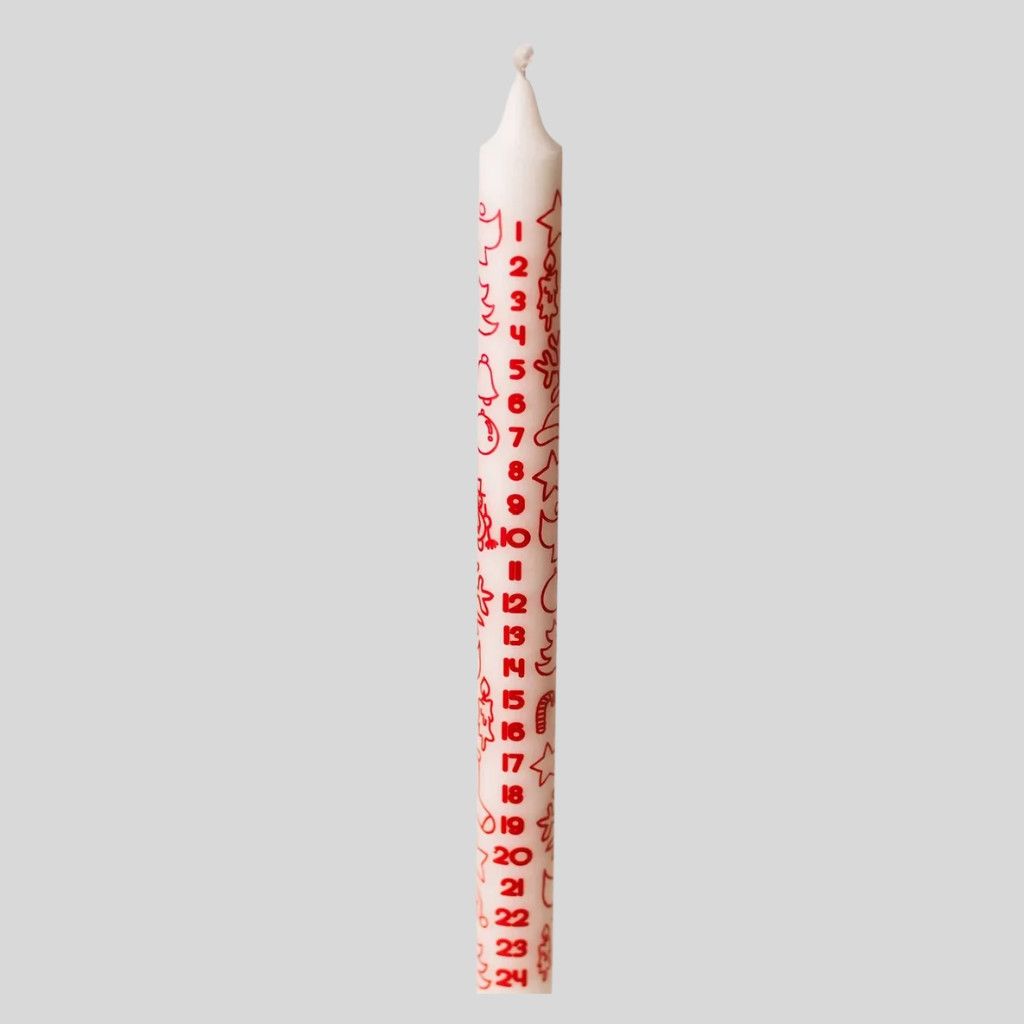 White Advent taper candle with red print for counting down to Christmas.