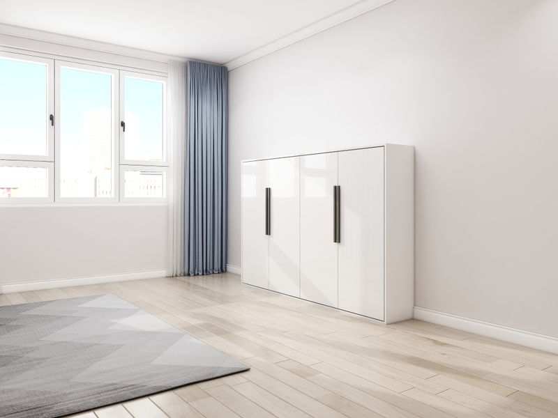 High-glossy white murphy bed in a horizontal style which is folded up in a cabinet position for discreet design.