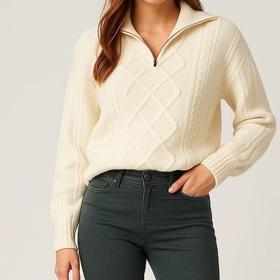 Model draagt gebreide kabeltrui met rits in een ivoor witte kleur