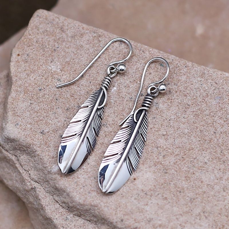 Feather dangle earrings designed by artist Lena Platero