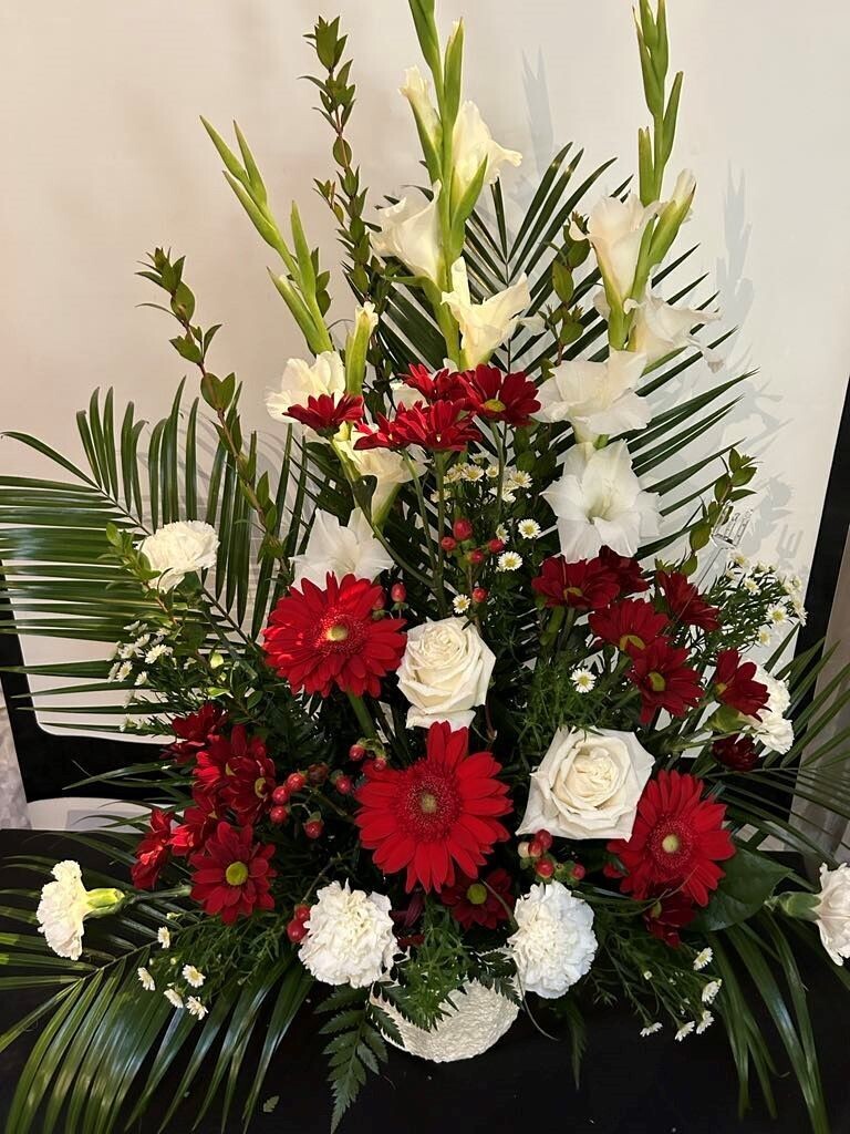 Panier funéraire composé de glaïeul (en saison), gerbera, rose et marguerites
