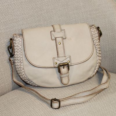 Sac bandoulière en cuir beige.