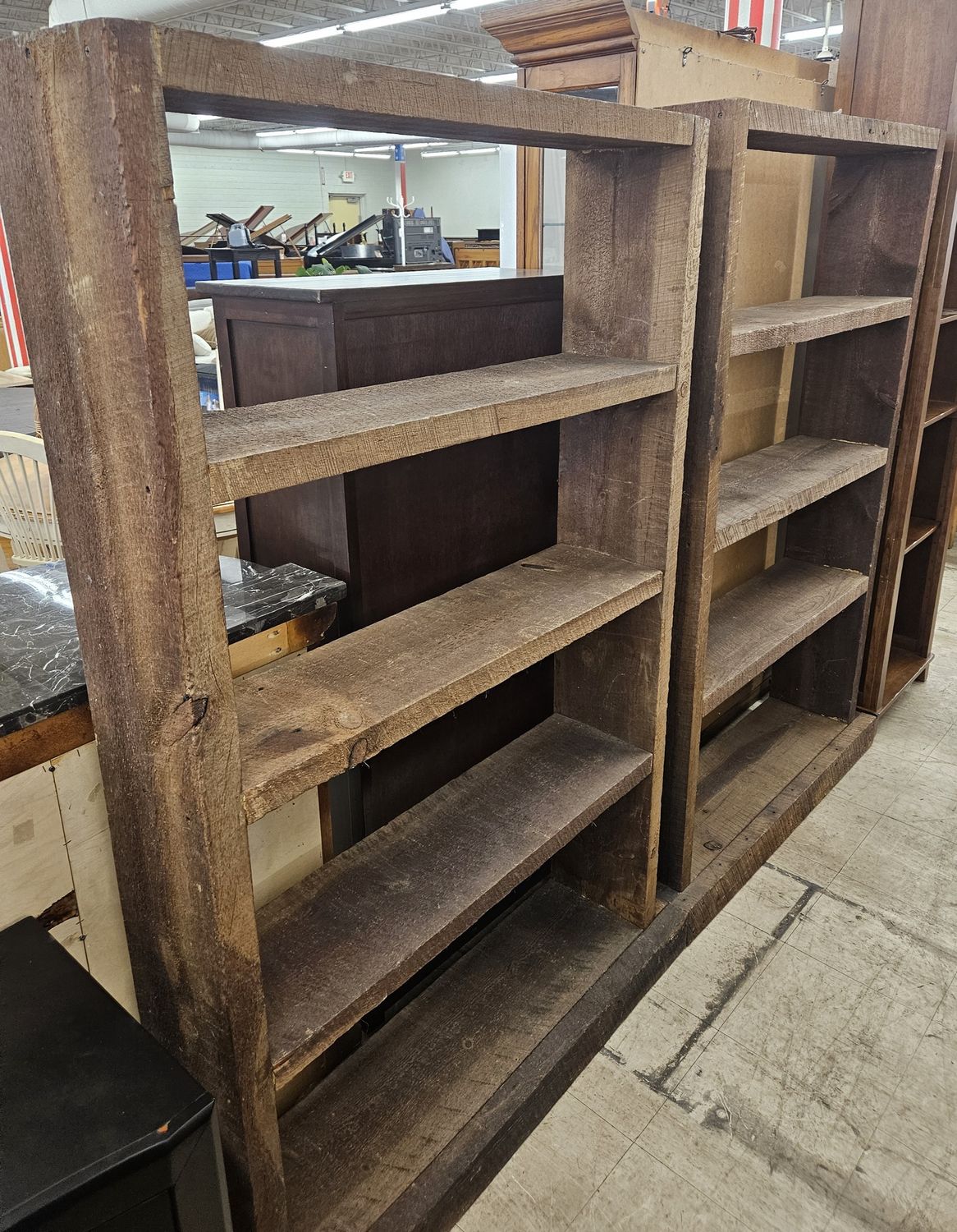 Two tall, rustic wooden bookshelves