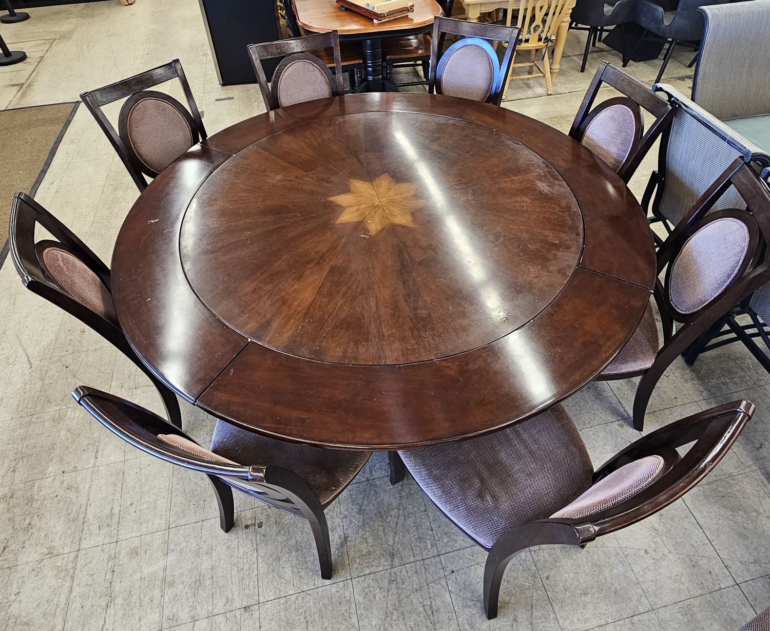 dark wood table with a leaf extension and ten upholstered chairs
