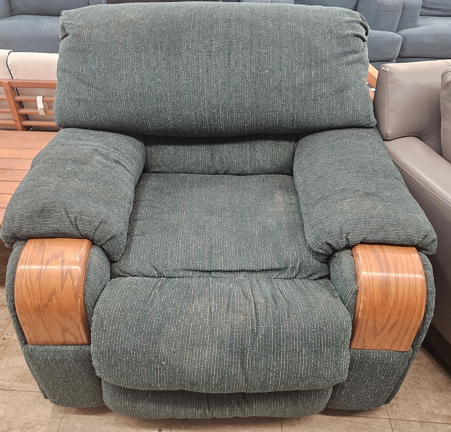 Green, heavily cushioned recliner chair