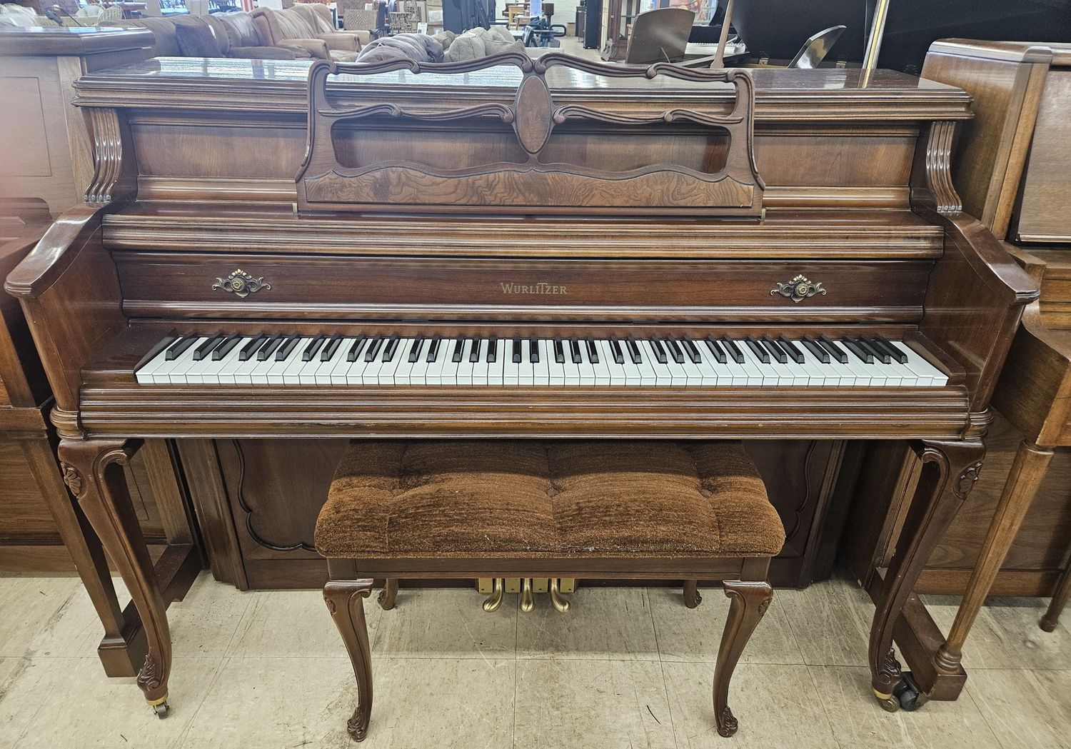 Wurlitzer console piano with a matching bench.