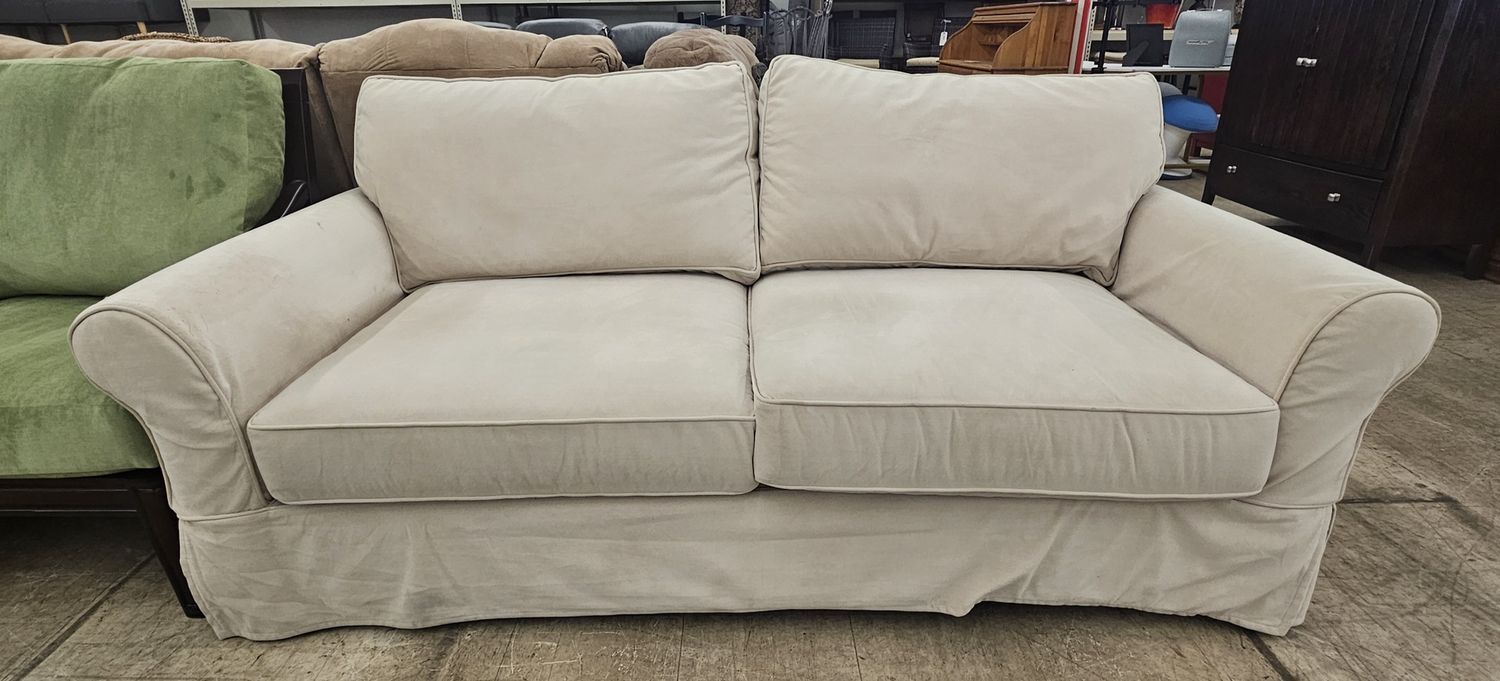Cream slipcovered loveseat