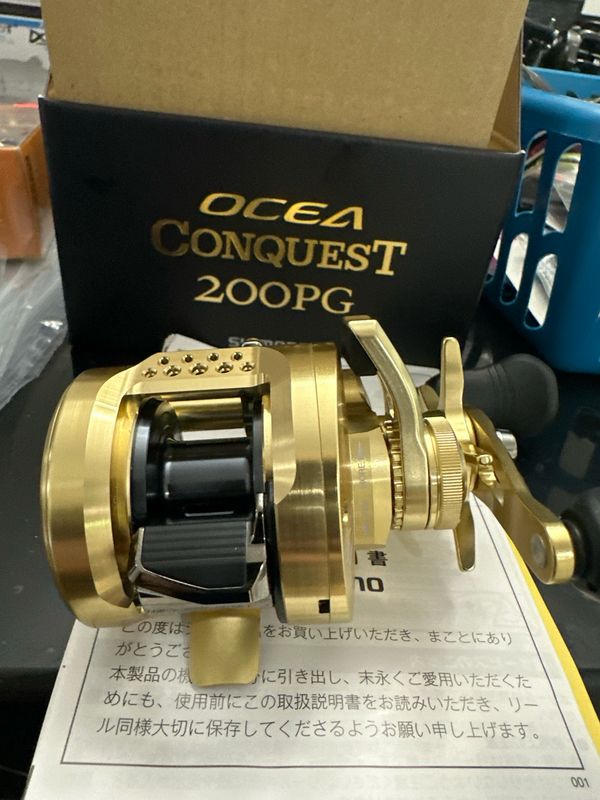Shimano Ocea Conquest 200PG. Gorgeous Round Baitcast Reel. 11/2 BB, 4.8:1, 17.6lb Drag. New In Box.