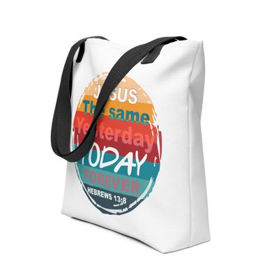 A white canvas tote bag with black handles and a colorful retro sun design featuring a Bible verse