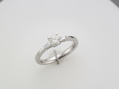 18 carat white gold brilliant cut diamond solitaire ring with baguette diamond shoulders