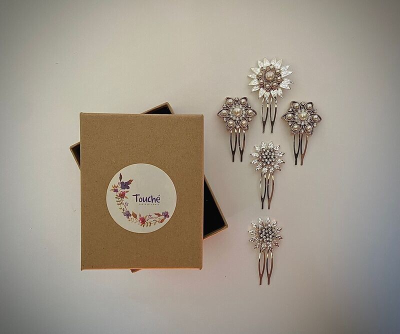 Pack compuesto por cuatro horquillas de estrellas de unos 3 cm y una estrella de 3,5 cm. Las estrellas están formadas por detalles en plata y dorado envejecido aportando unos contrastes geniales al look. Cuentan con pequeños cristales transparentes y perlas.