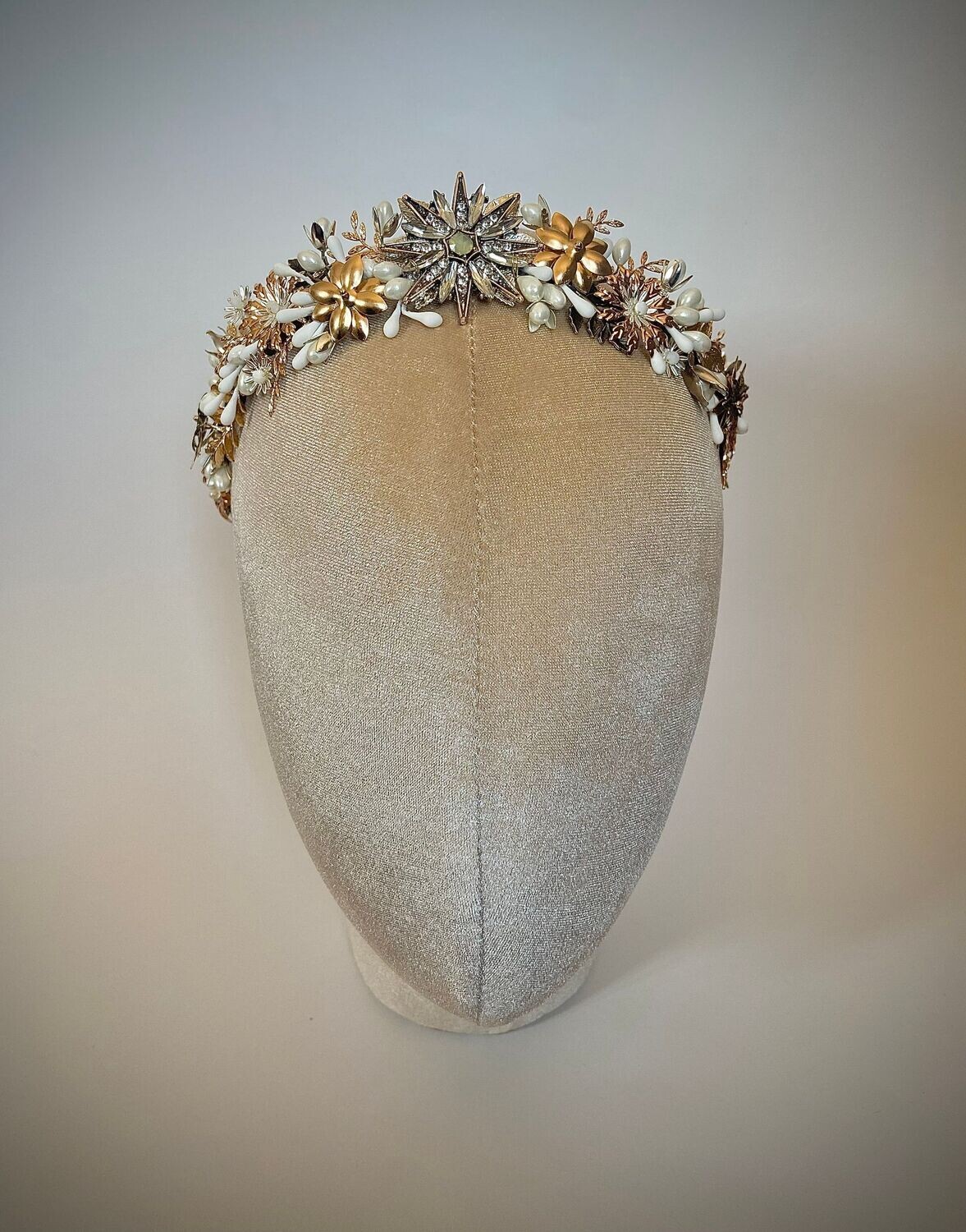 Tiara de novia compuesta por diferentes detalles dentro de los que destacan las flores, las hojas y los pistilos con una estrella central. Se caracteriza por ser una tiara muy tupida con un ligero acabado en pico en el centro.

Queda preciosa si la combinas con horquillas en la parte trasera de la cabeza ya que se conseguimos equilibrar el look aportando luminosidad en la zona posterior.

Su peculiaridad es que puede utilizarse también como tocado trasero por su tamaño, consiguiendo con una misma pieza lucir dos looks.