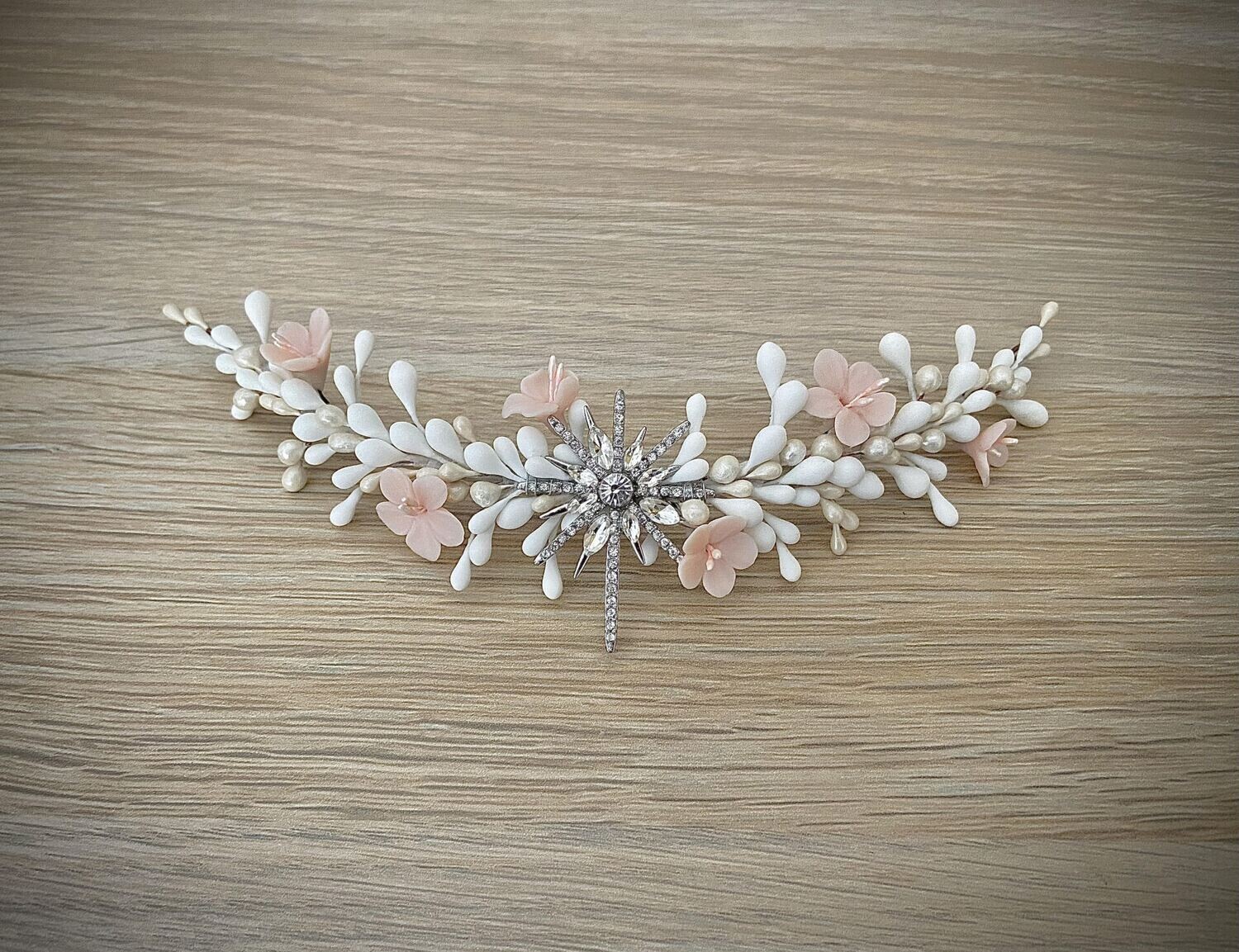 Tocado compuesto por una estrella central en plata o en dorado con pistilos alrededor en tonos blancos y nacarados y 6 flores en el tono que elijas. Es un tocado de porcelana y metal sencillo que aporta un toque romántico al look.

En comentarios puedes añadir el tono de flores que te gustaría que tuviera el tocado y puedes enviarme por Whatsapp 696088428 o mail info@touchebycari.com fotos para saber el tono exacto que necesitas.