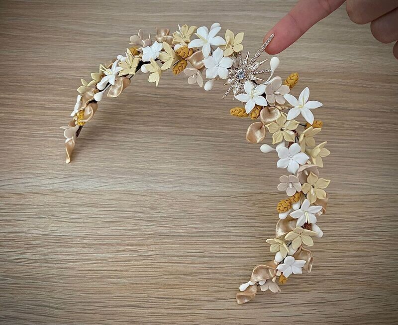Tiara de flores de porcelana en tonos blancos, amarillos, crudos y dorados con estrella central con base dorada.