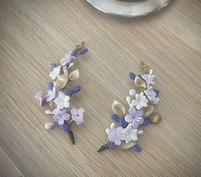 Tocado de porcelana compuesto por dos piezas de unos 10 cm cada una en tonos violetas, blancos y morados perfectas para coleta.