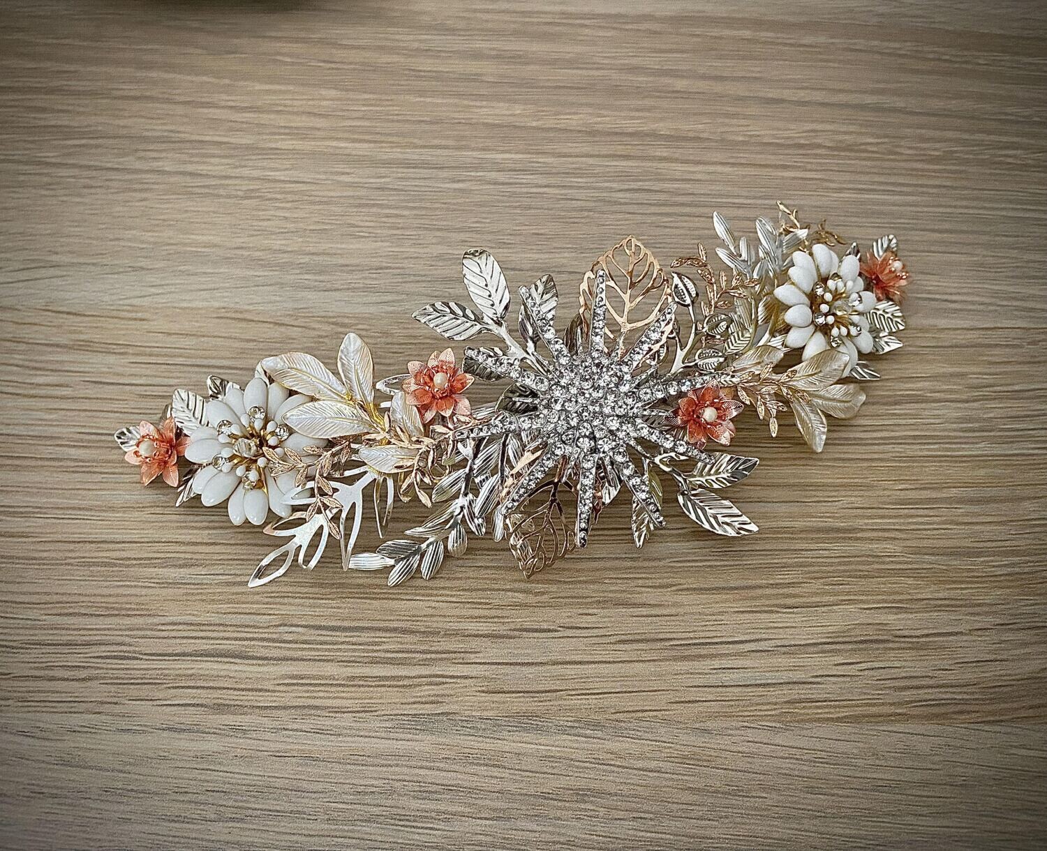 Tocado de metal y cristales de unos 20 cm de longitud compuesto por diferentes detalles en tonos plata, dorado y cobre.