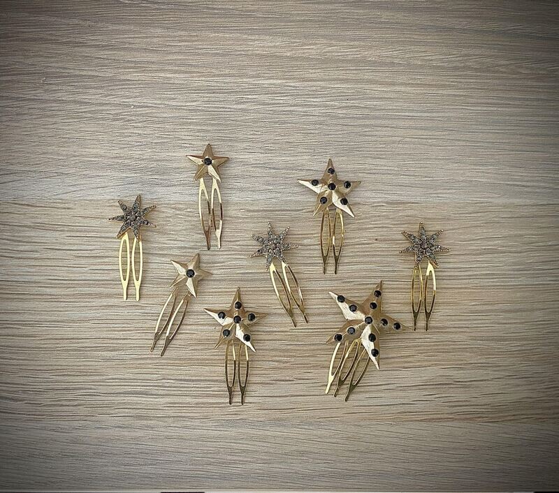 Pack de 8 horquillas de estrellas de diferentes tamaños compuesto por 5 estrellas de porcelana nacaradas con cristales y 3 estrellas de cristales con fondo dorado.