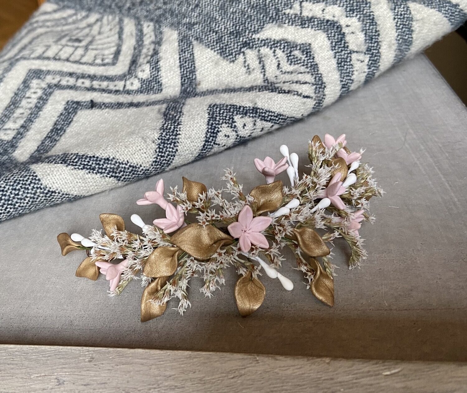 Tocado de porcelana y flor preservada de unos 18 cm de longitud en todos dorados, crudos y rosa empolvado.