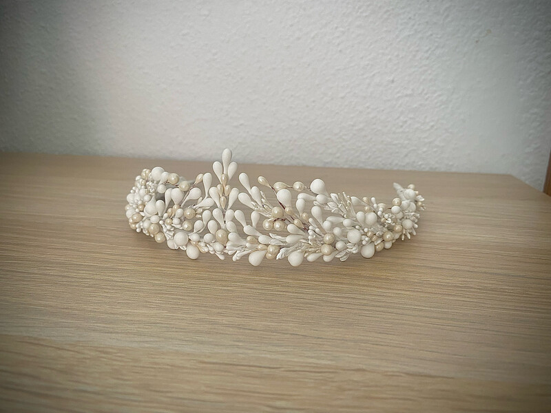 Tiara de pistilos blancos y nacarados con una altura de unos 4-5 cm en su parte delantera central.

Está compuesta por cientos de pequeños pistilos de entre 1 y 4 mm en tonos blancos y nacarados. El conjunto aporta elegancia y frescura al look de novia por su sencillez y delicadeza.

No dudes en decirnos pistilos de qué otro color te gustaría incluir para personalizar tu tiara.
