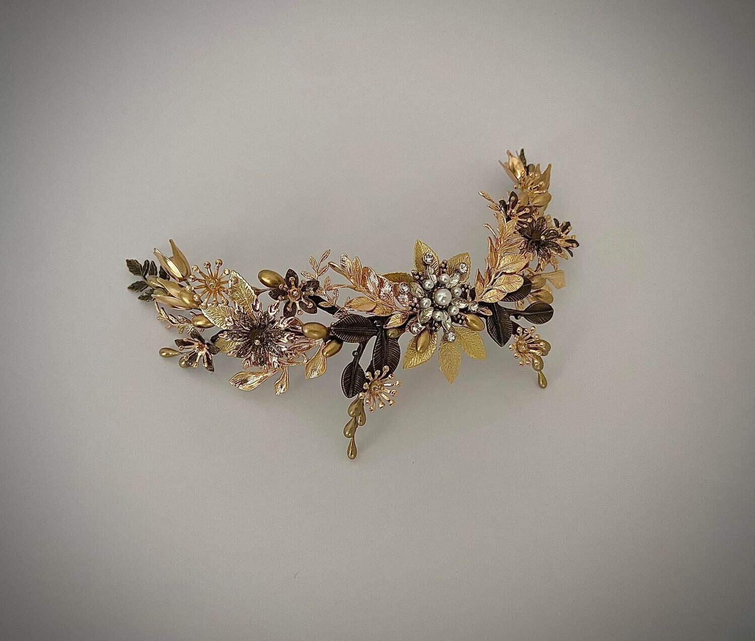 Tocado de metal formado por múltiples detalles en varios tonos de dorado conformando una pieza elegante y sofisticada que gracias a sus ramificaciones se puede adaptar a un sinfín de peinados de novia.

Esta pieza se puede hacer incluyendo algunos detalles de color. No dudes en contactarme si deseas hacer alguna modificación.
