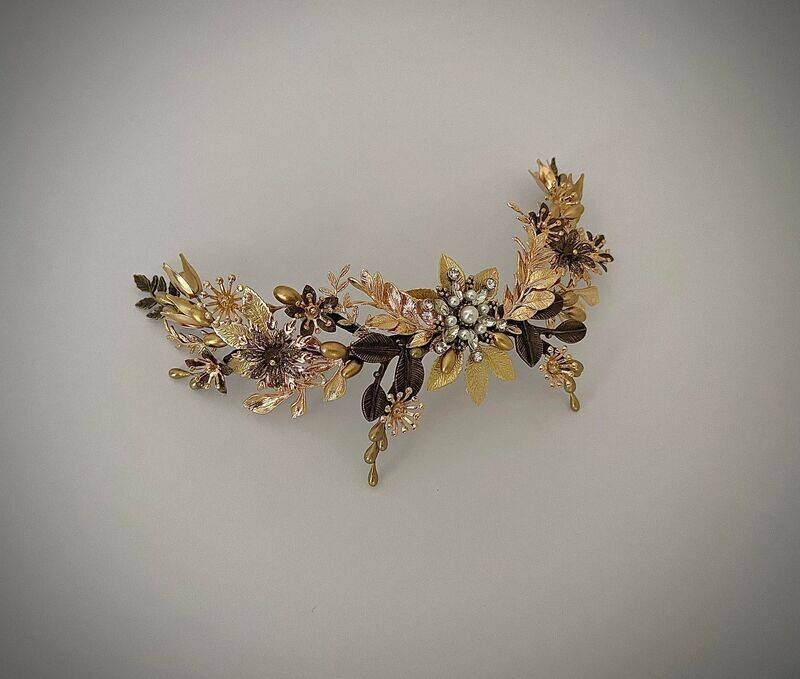 Tocado de metal formado por múltiples detalles en varios tonos de dorado conformando una pieza elegante y sofisticada que gracias a sus ramificaciones se puede adaptar a un sinfín de peinados de novia.

Esta pieza se puede hacer incluyendo algunos detalles de color. No dudes en contactarme si deseas hacer alguna modificación.